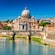 St. Peter’s Basilica in Vatican City seen beyond a historic bridge over the Tiber River in Rome